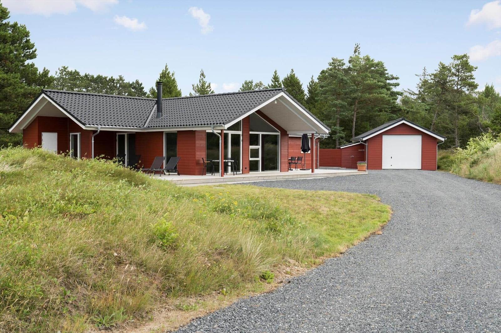 Large living and dining area with wood wall, glass doors, and wood stove.