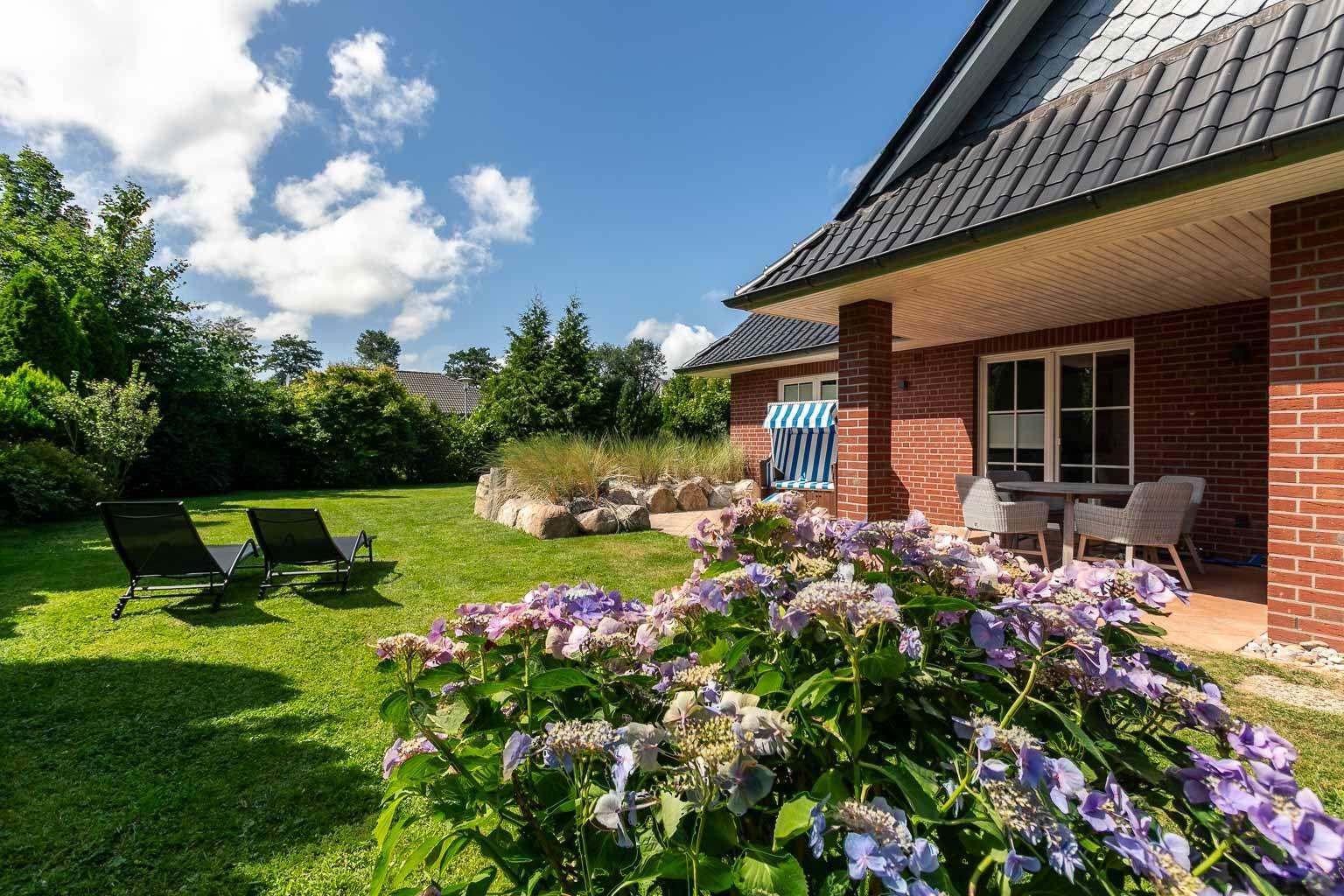 Sonnige Gartenterrasse mit Dünenwall...
