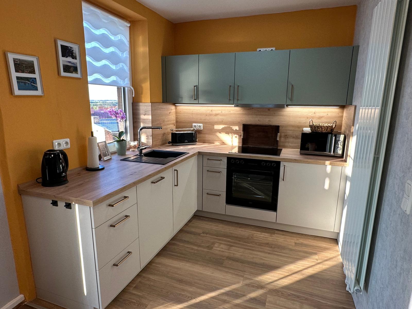 Küche mit Geschirrspüler, Backofen und Mikrowelle