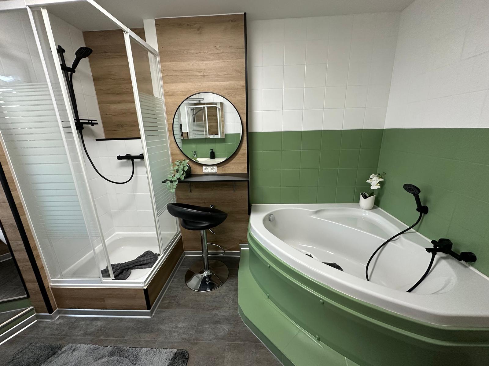 Badezimmer mit Badewanne, Dusche und Kosmetikbereich