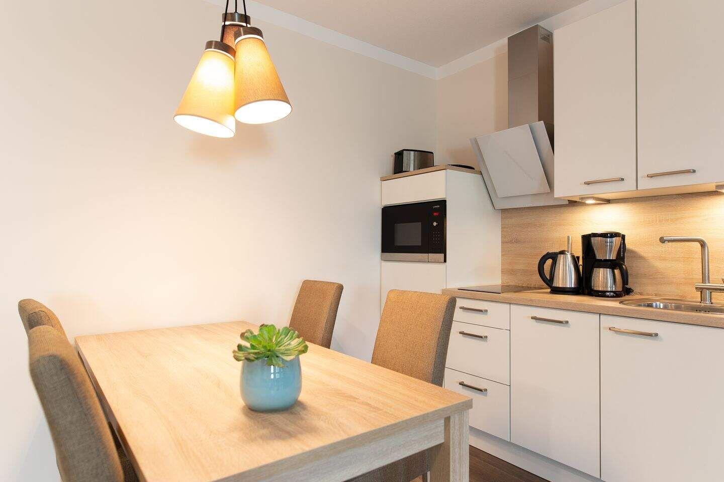 Küche mit Essbereich, Mikrowelle, Kaffeemaschine und Küchenspüle.