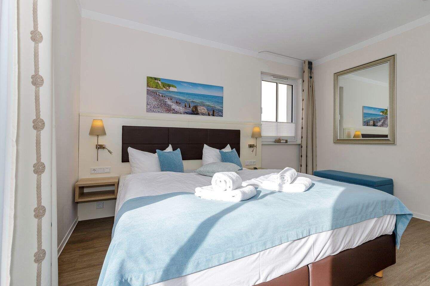 Schlafzimmer mit Bett, Wandbild und Spiegel