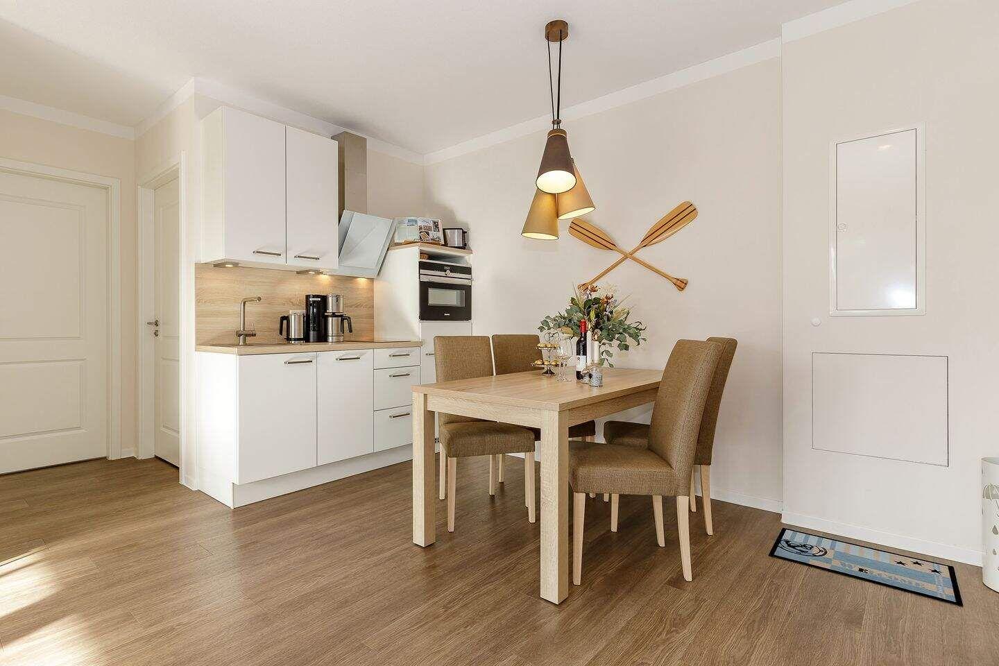 Küche mit Essbereich, Holztisch, Stühle und Wanddekoration mit Ruder.