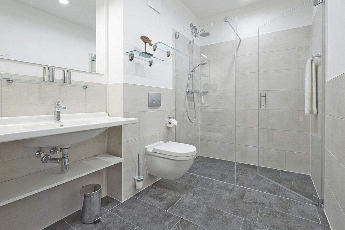 Badezimmer mit Dusche, Toilette und Waschbecken.