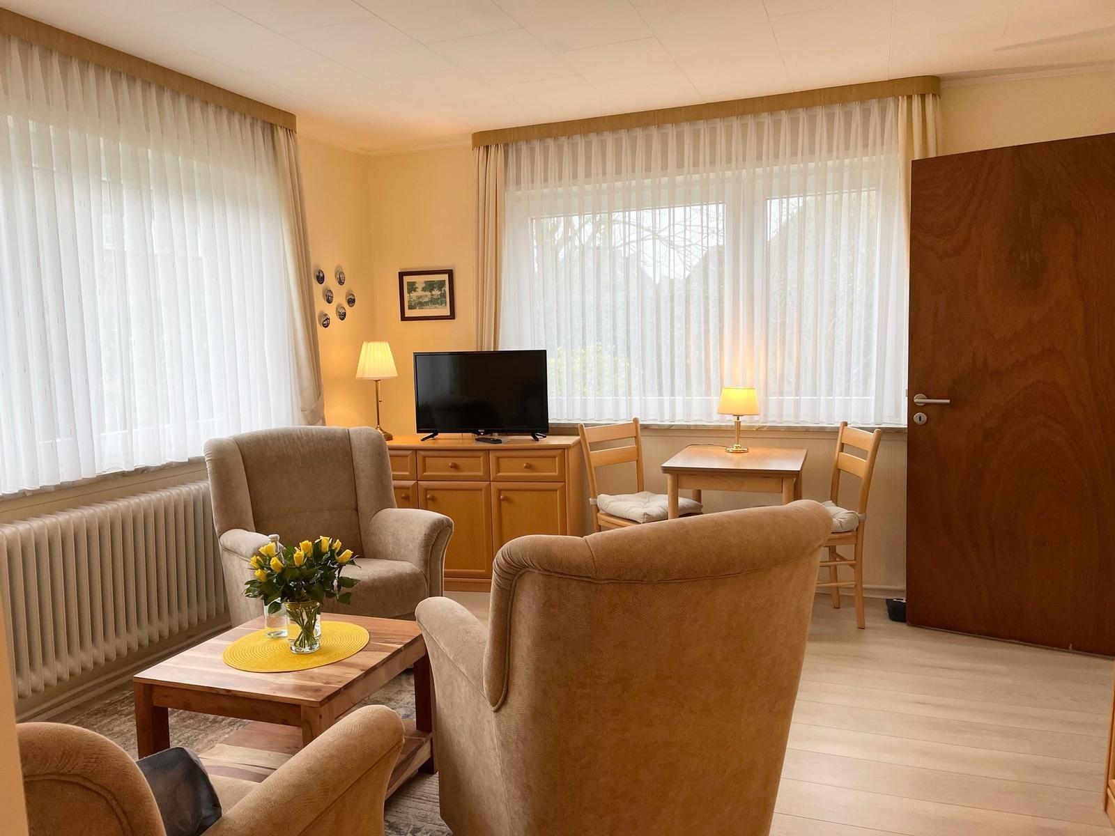 Gemütliches Wohnzimmer mit Sitzecke und Fernseher