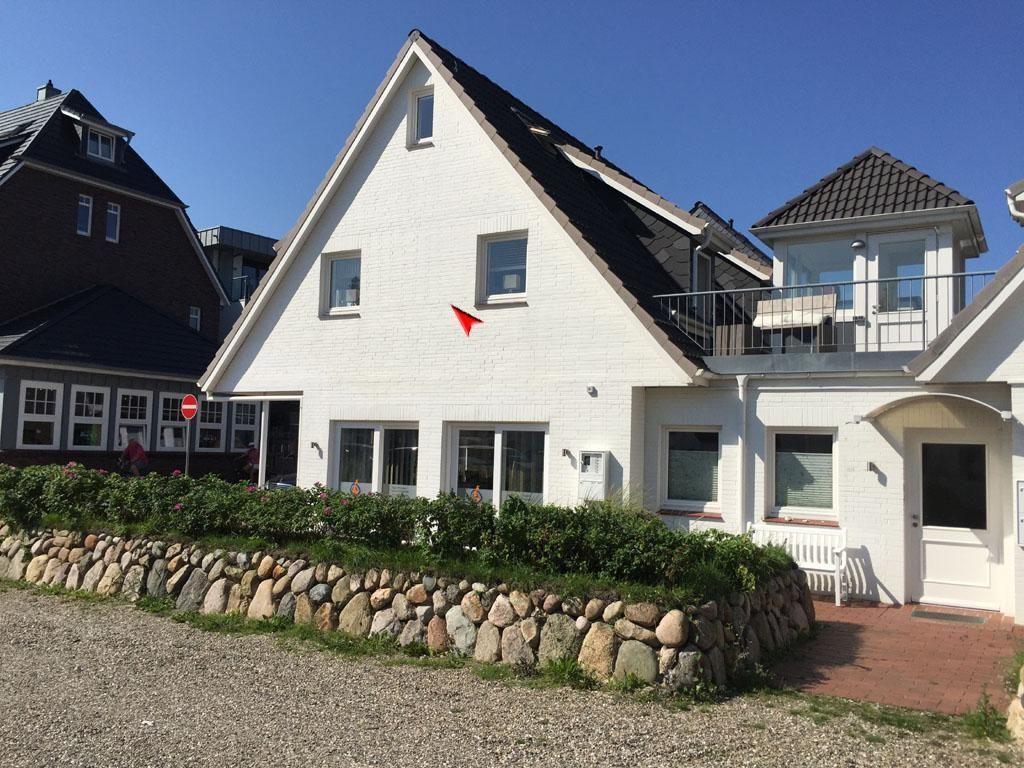 Wohnung mit Küche, Essbereich, Schlafzimmer und Bad. Treppenturm und Bank mit Tisch vorhanden.