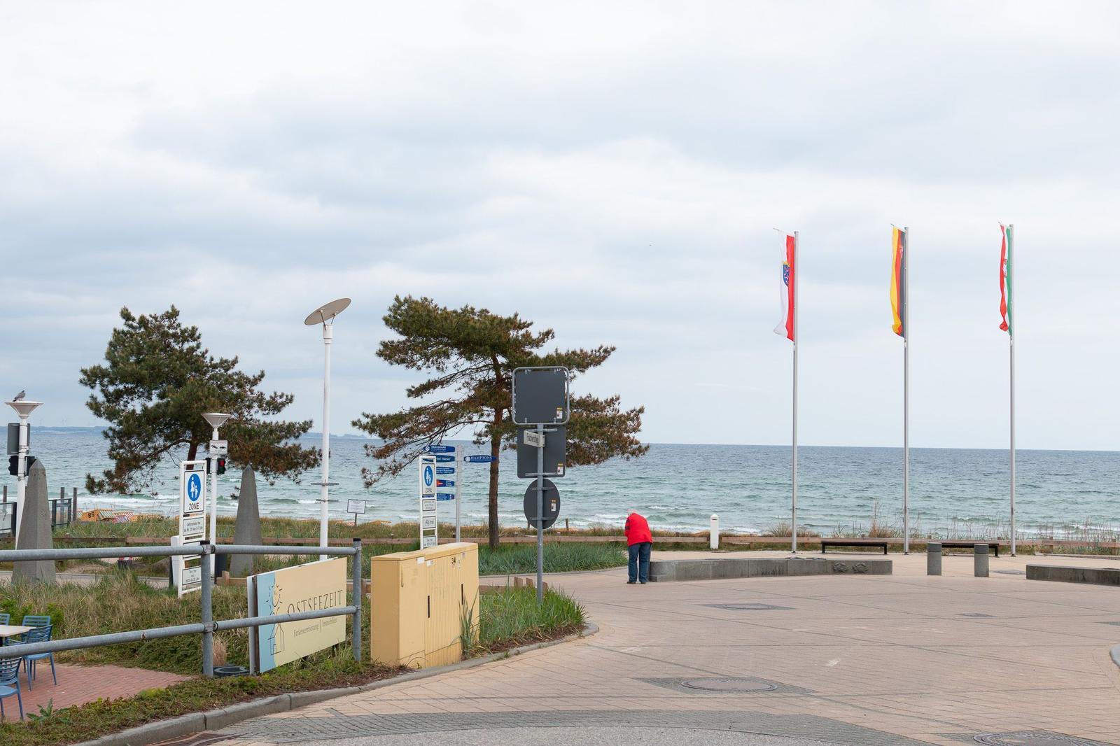 Moderne Wohnanlage mit gelben Balkonen und Restaurant im Erdgeschoss.
