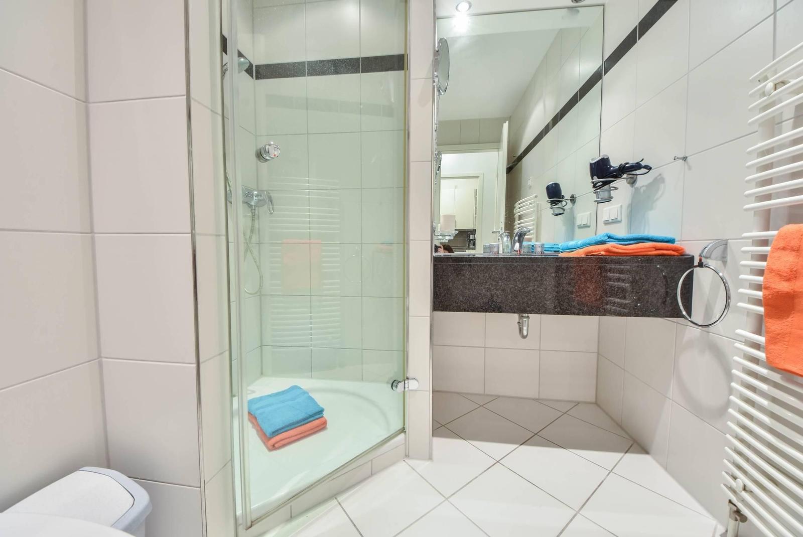 Badezimmer mit Dusche, Toilette und Handtuch