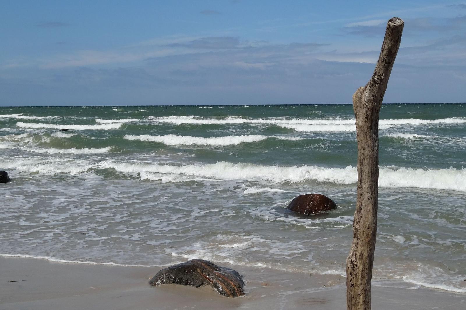 Gestein mit Löchern am Strand. Meeresblick im Hintergrund.