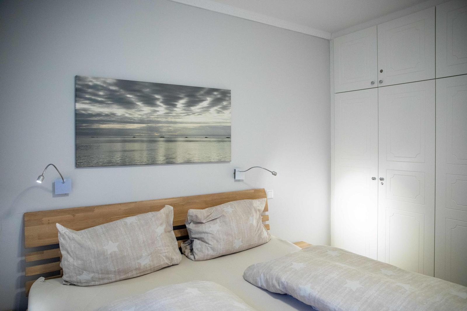Schlafzimmer mit Bett, Kleiderschrank und Wand-TV.