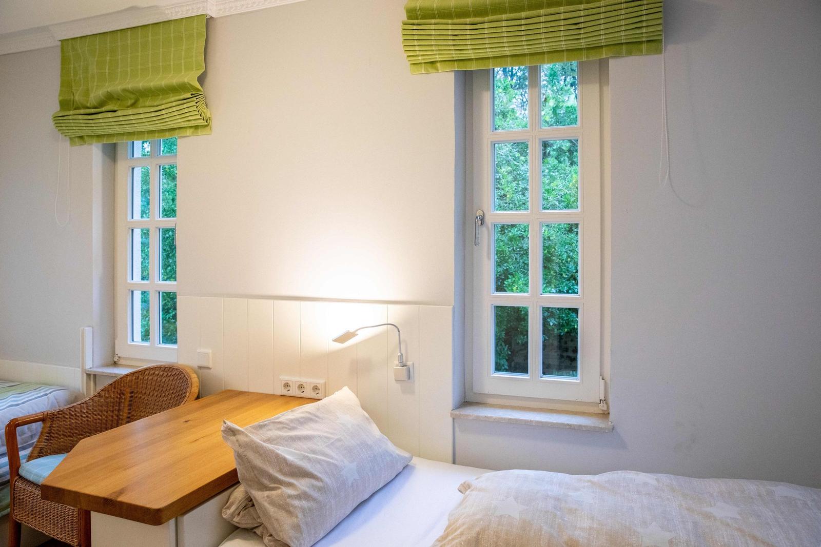 Bad mit Duschkabine, Toilette und Fenster mit Glasmosaik.