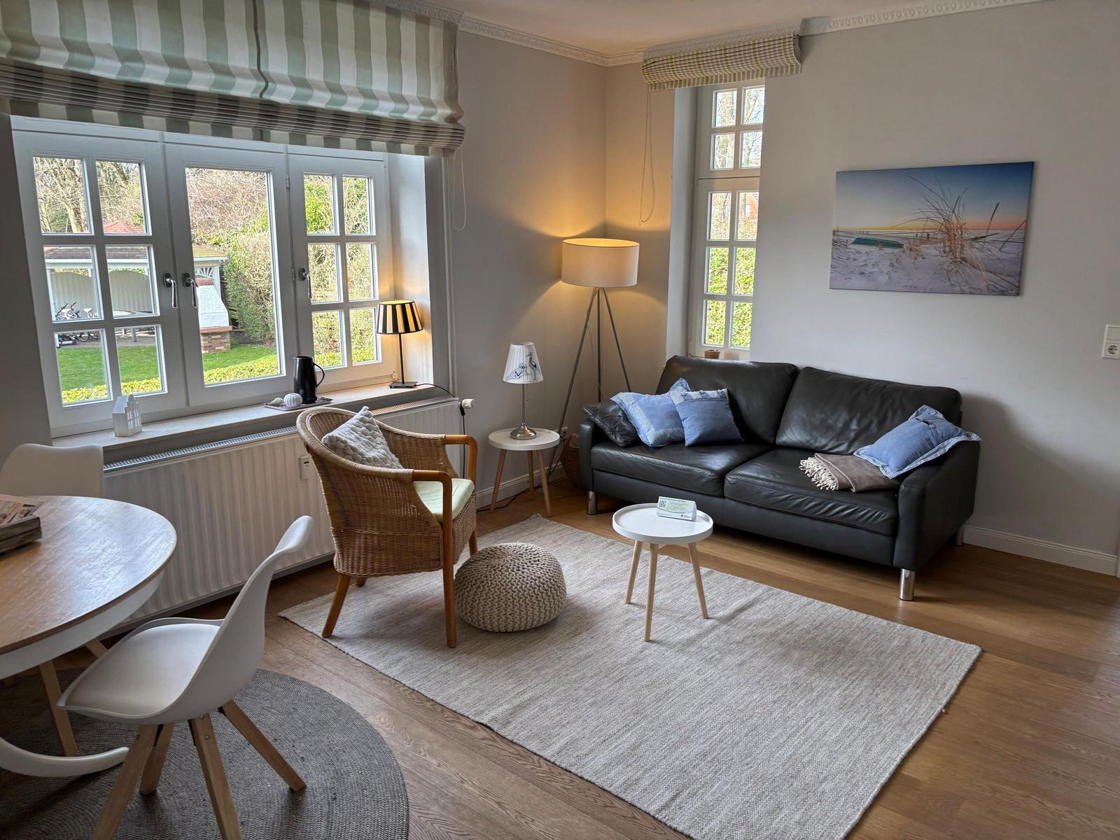 Küche mit Essbereich, runder Tisch, weiße Stühle, Fenster mit Blick auf Dächer.