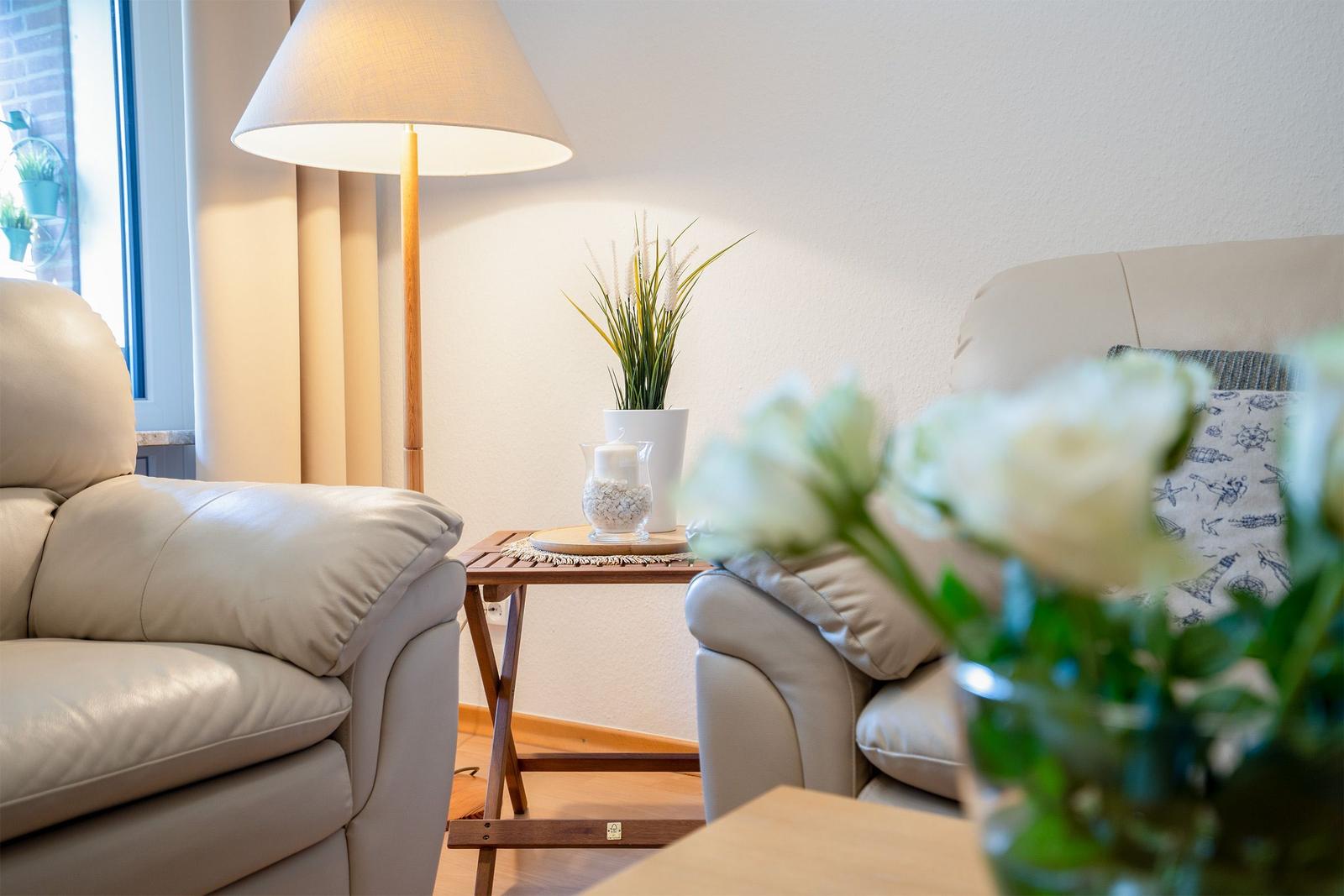 Wohn- und Essbereich mit Sofa, Sessel, Esstisch und Bücherregal.