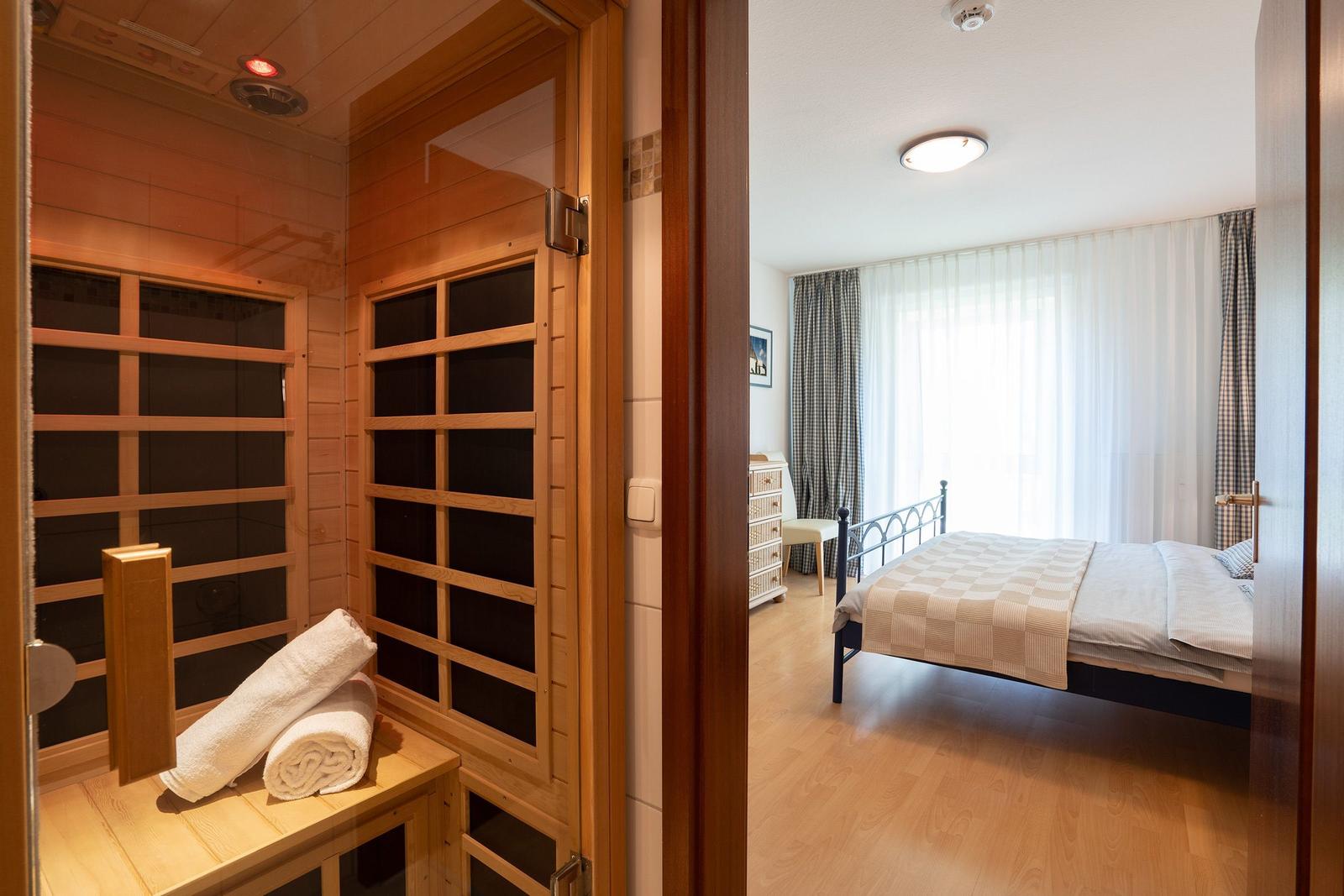 Sauna mit Holzbank und zwei gefalteten Handtüchern.