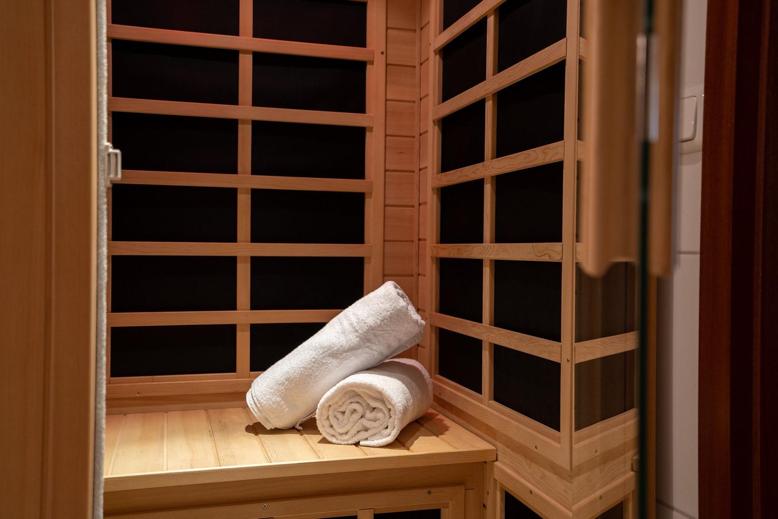 Bad mit Waschbecken, Spiegel und Sauna. Tür führt ins Schlafzimmer.