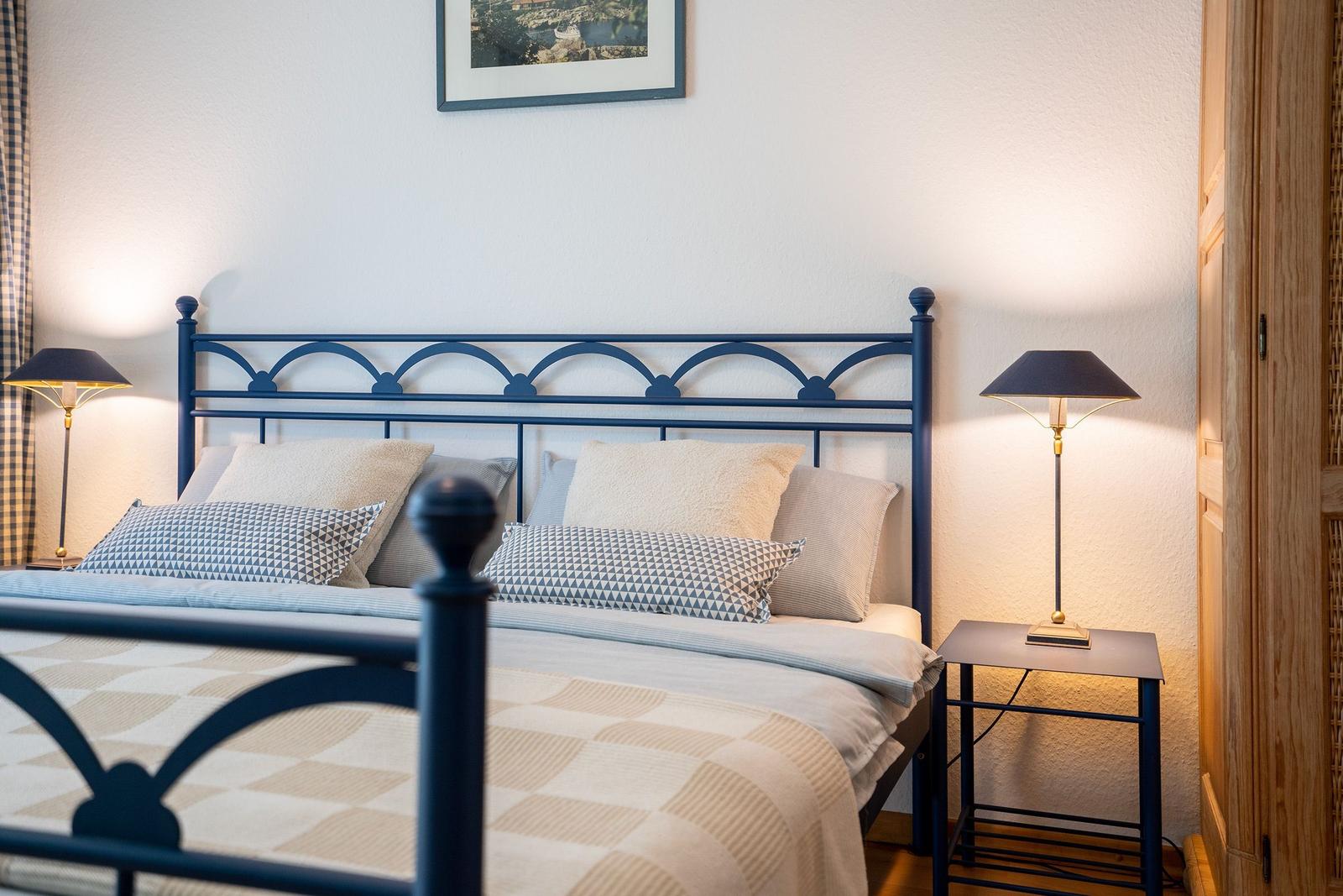 Schlafzimmer mit Bett, Schrank und Wandbildern