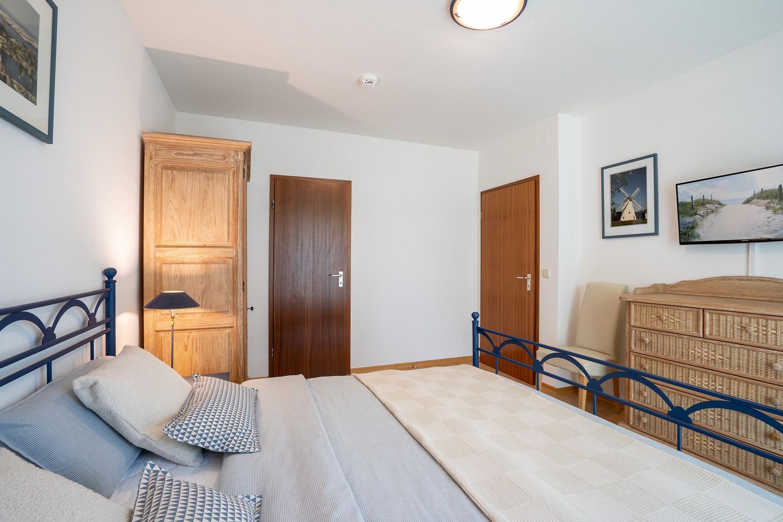 Schlafzimmer mit Bett, Nachttischen und Kleiderschrank.