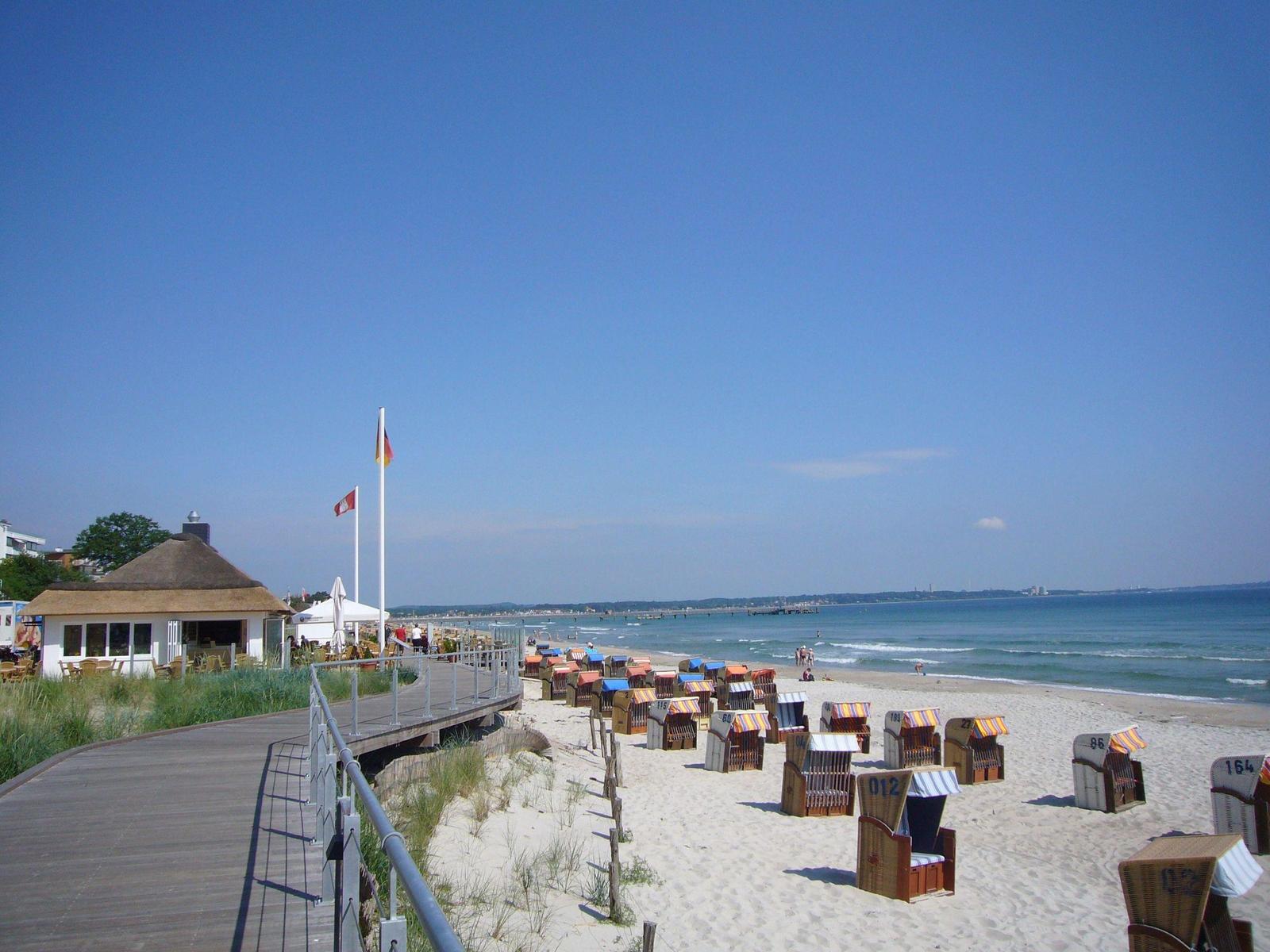 Sonnenuntergang über dem Meer mit Pier und Pavillon an der Strandpromenade.