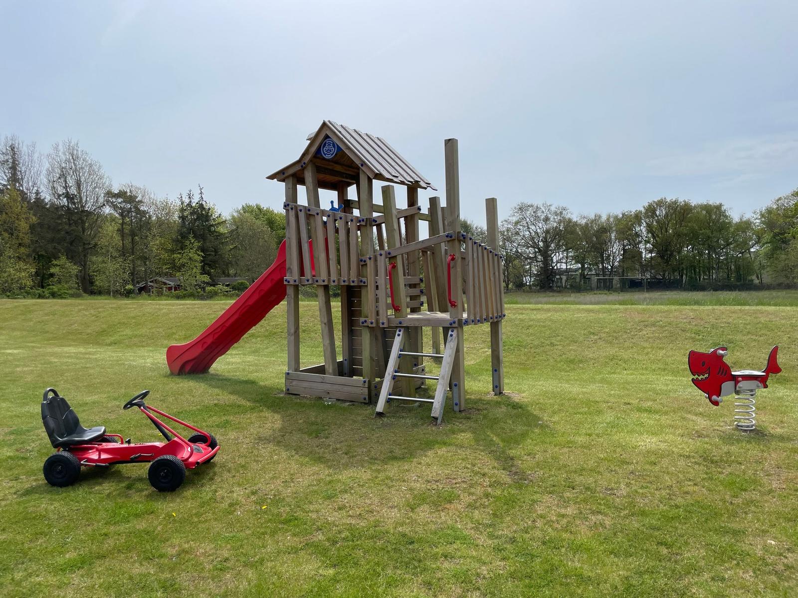 Roter Rutschbereich und Schaukel im Garten vor Ferienhaus