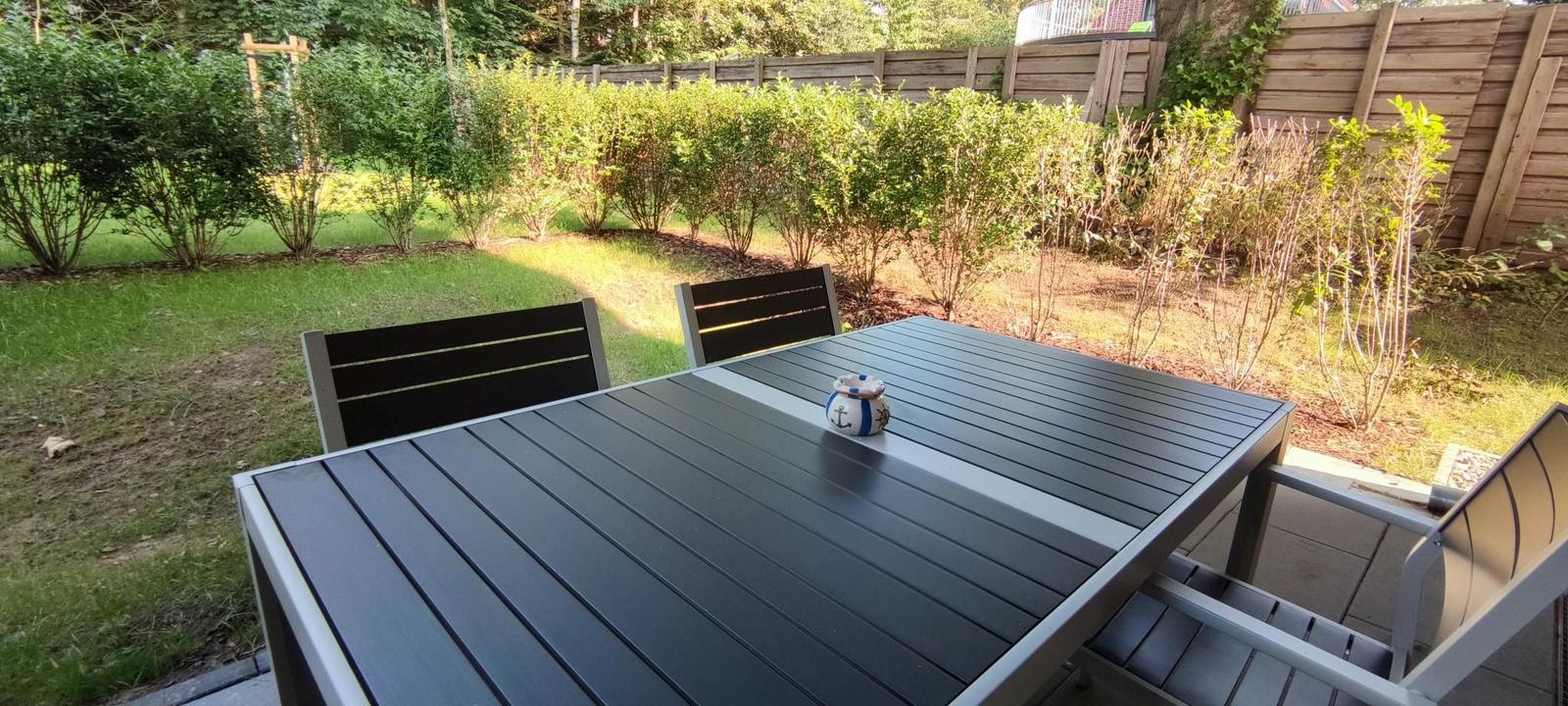 Roter Rutschbahn und Schaukel im Garten vor Ferienhaus
