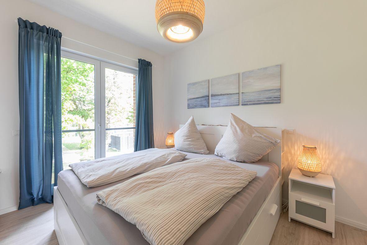 Zimmer mit Doppelstockbett, Schrank und Balkon mit Blick auf Grün