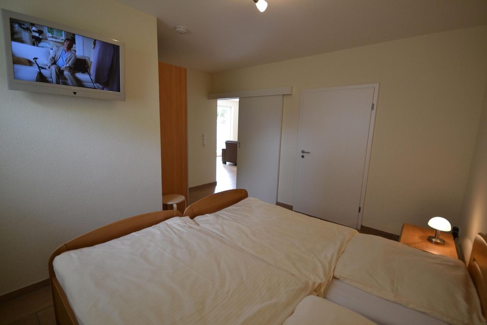 Flur mit Holzgarderobe, Kleiderständer und Bodenschrank.