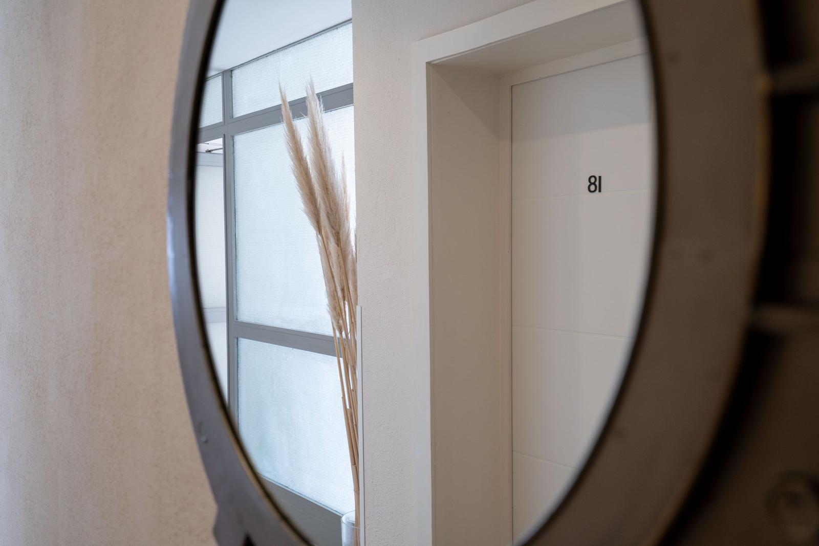 Eingangsbereich mit Treppe, Informationsmaterial und Blick auf Balkon.