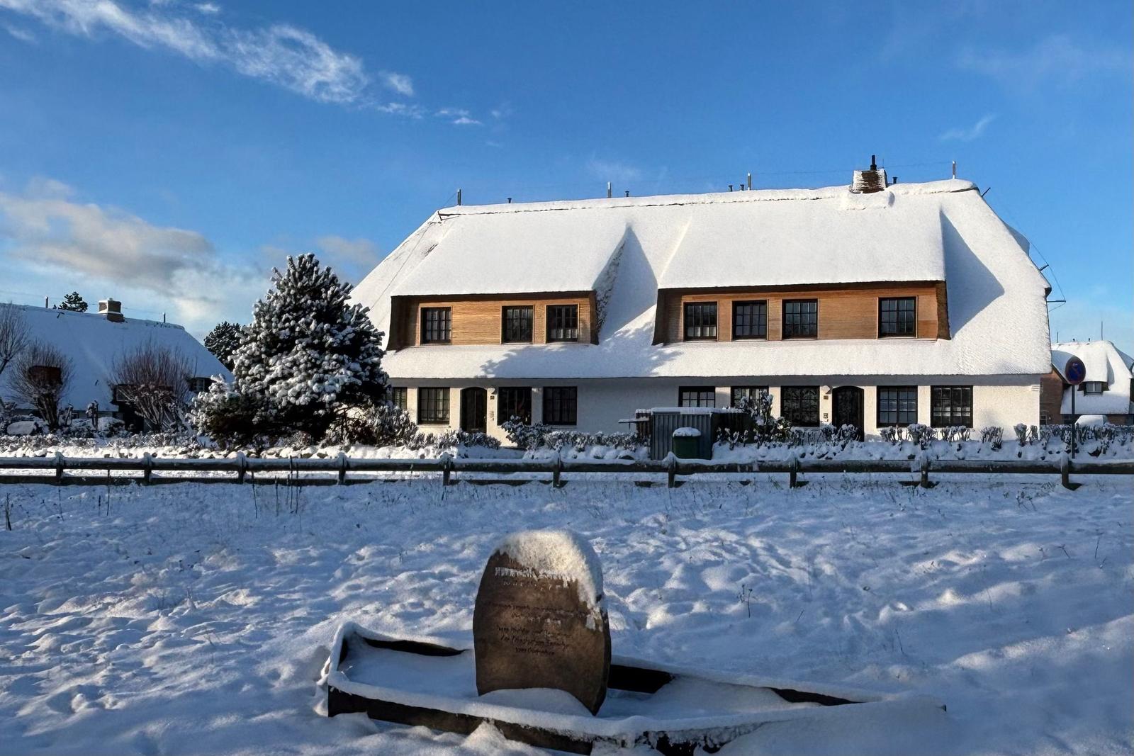 Schneeverhangenes Haus mit Holzveranda und Schneebedeckten Bäumen