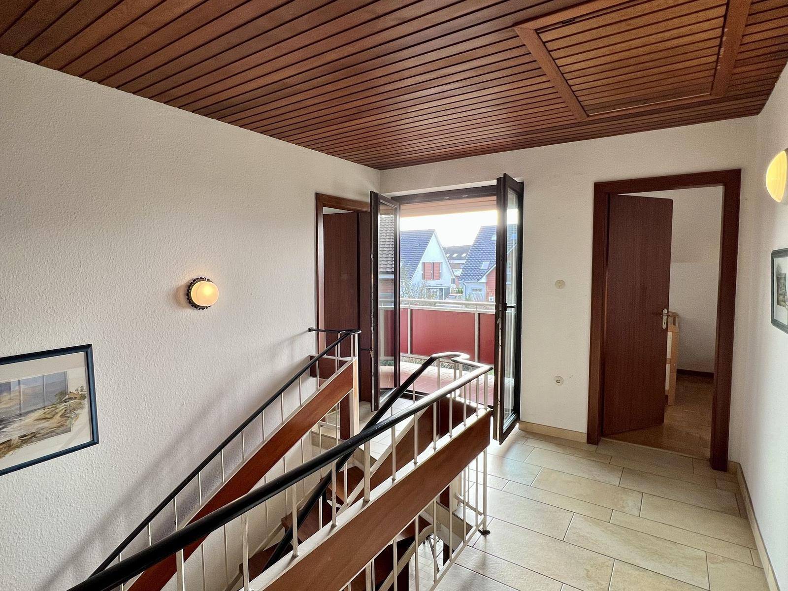 Schlafzimmer mit Doppelbett, Kinderbett und Fenster zur Terrasse.