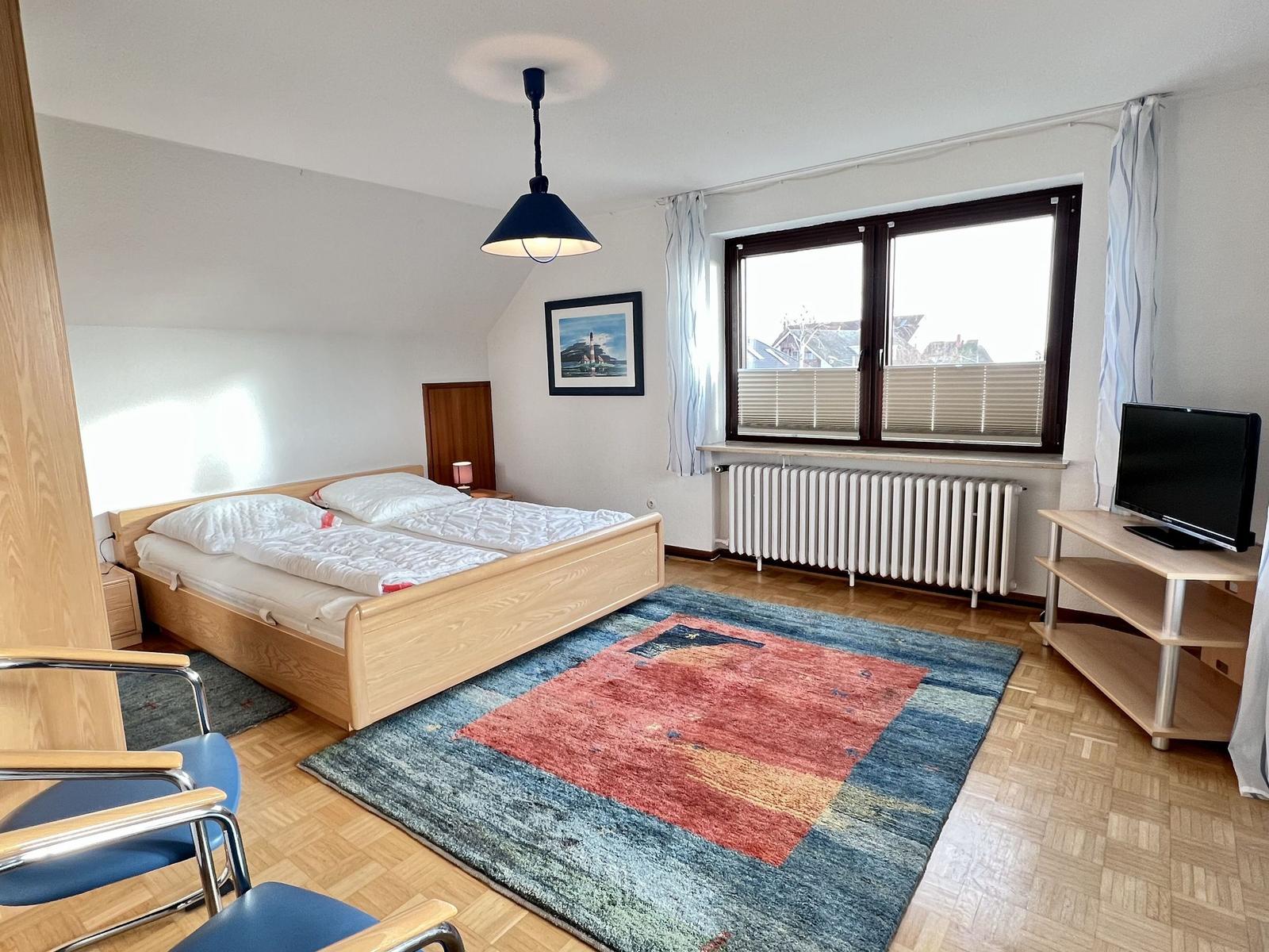 Ein Einfamilienhaus mit braunem Ziegeldach und weißem Zaun vorne.