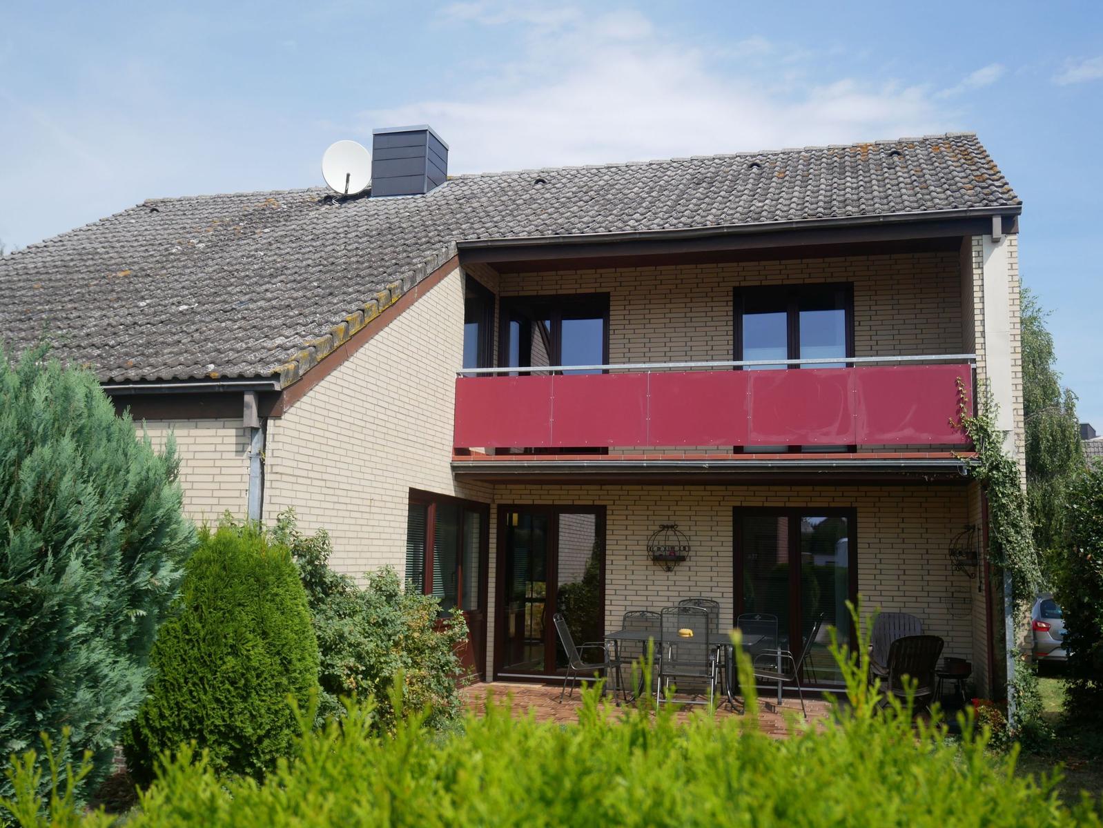 Zimmer mit Dachschräge, Fenster, zwei Stühlen und Tisch.