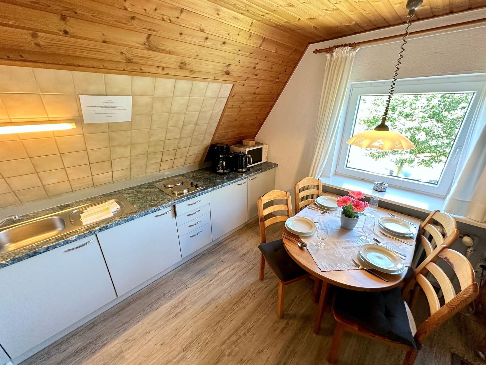 Wohnung mit Essbereich, Küche und Treppenhaus.