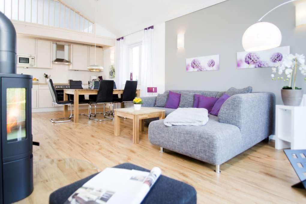 Wohn- und Essbereich mit Sofa, Esstisch und Holzboden.