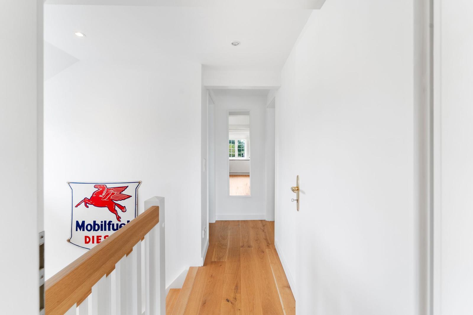 Hallenflur mit Treppe, Türen und Blick in Esszimmer.