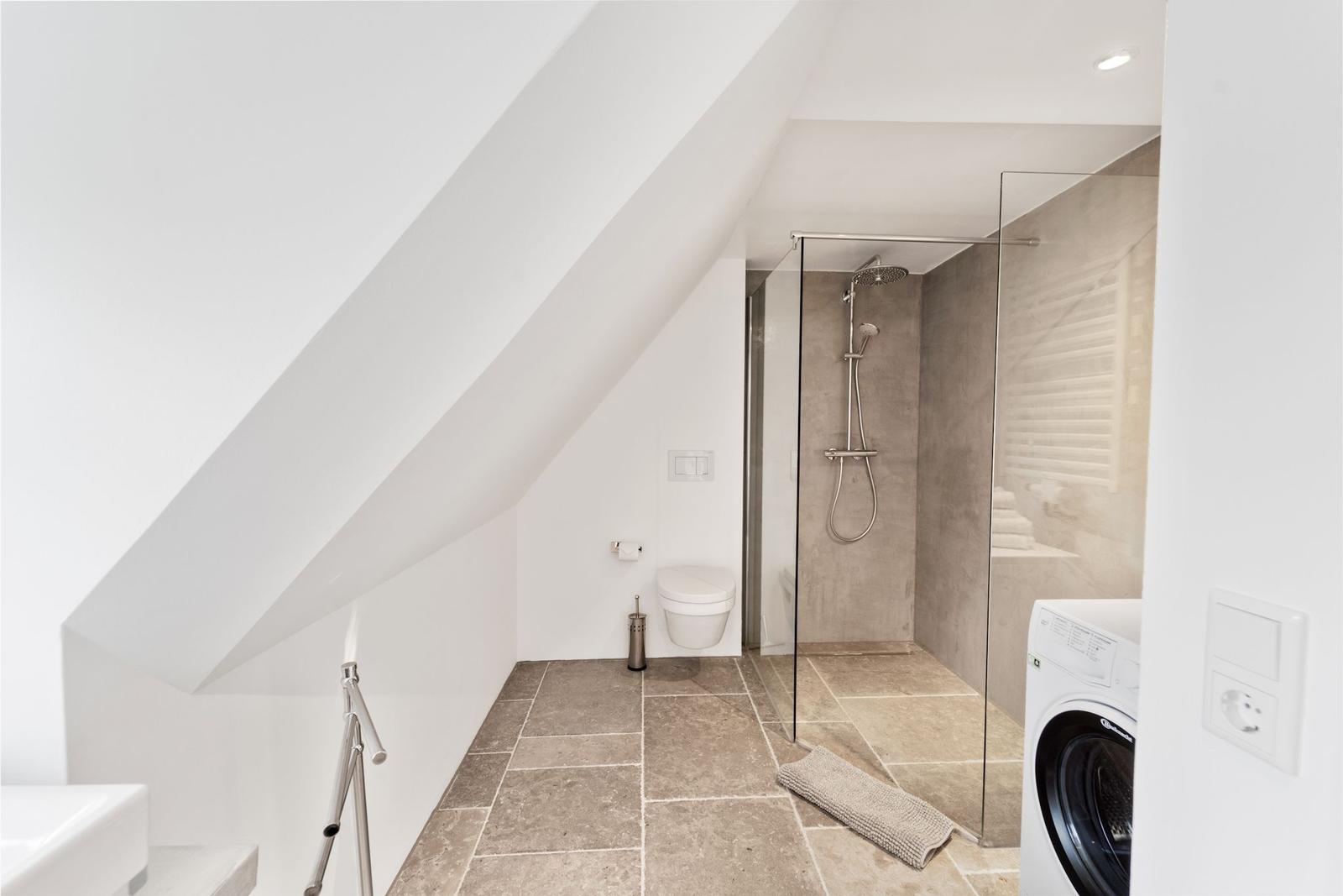 Badezimmer mit Dusche, Waschbecken und Heizkörper