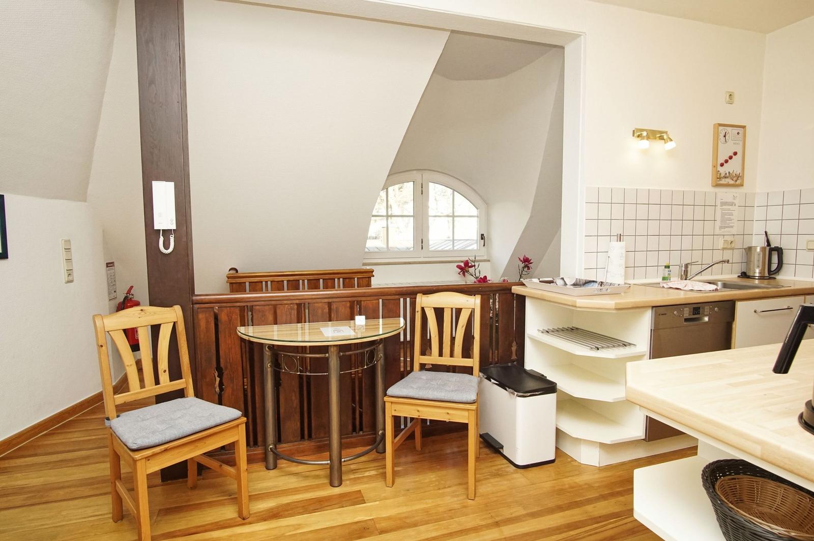 Schlafzimmer mit Holzbett und Kleiderschrank über Flur mit Spiegel und Garderobe.