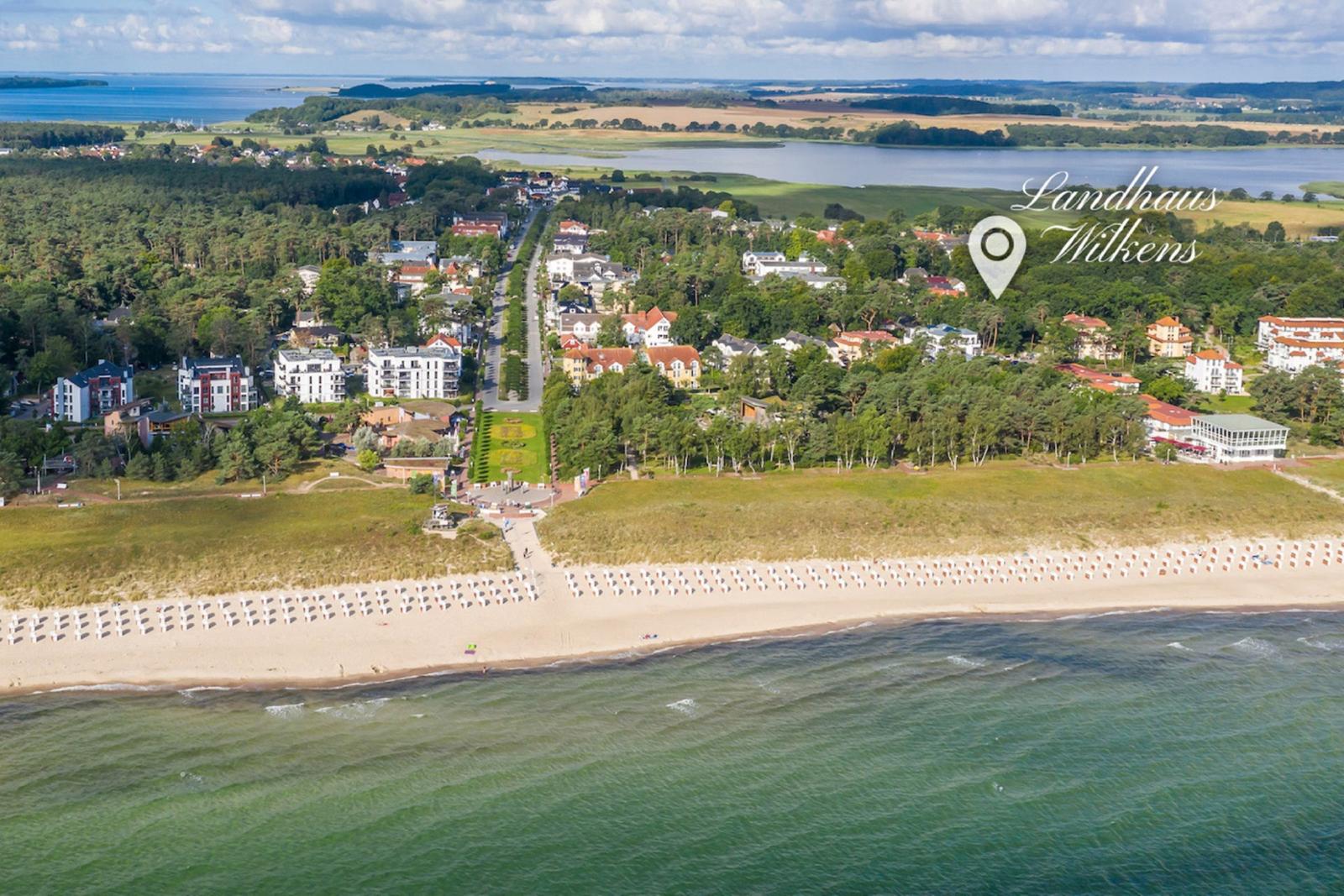 Strand mit Booten, Sonnenschirmen und Menschen am Meer.