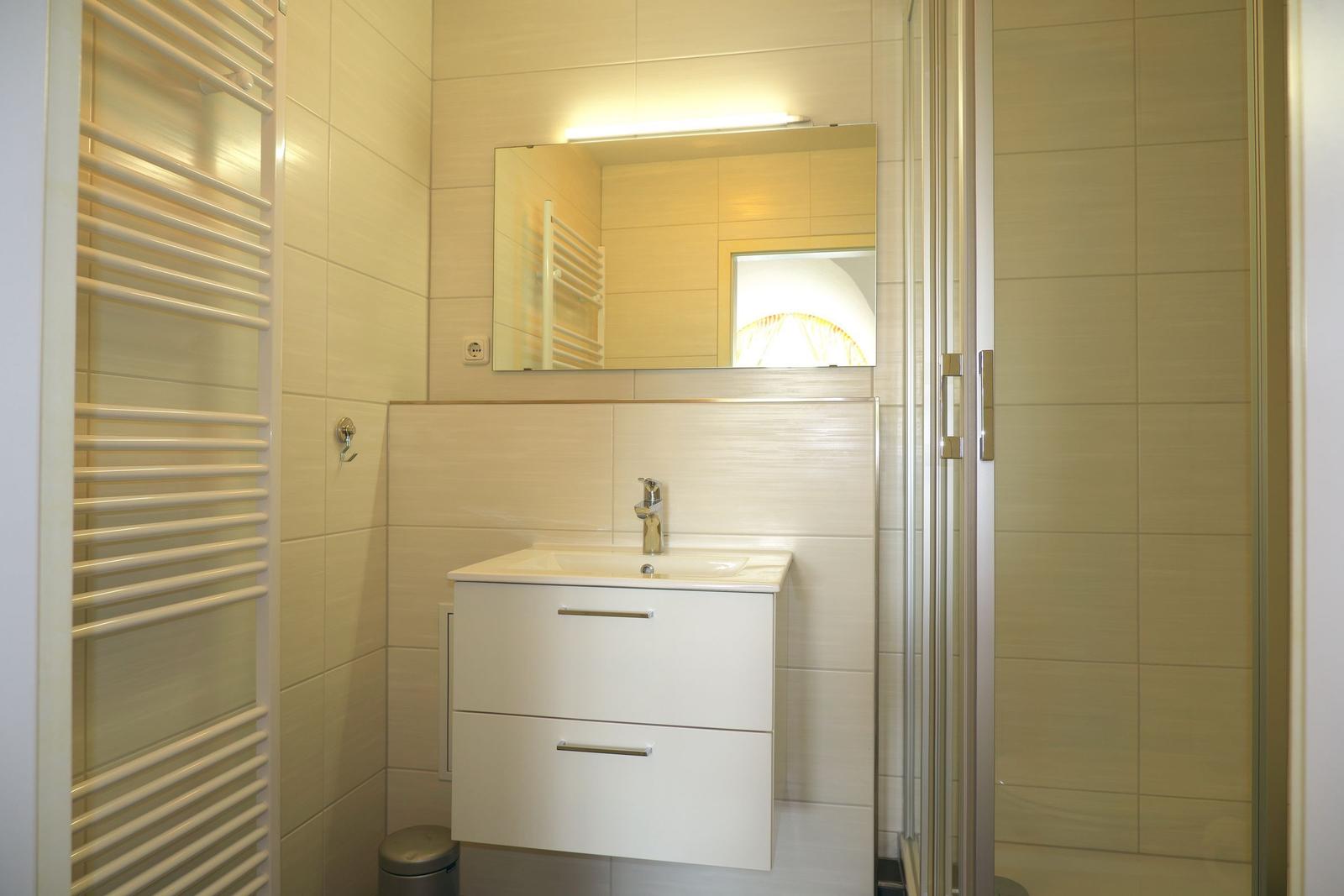 Badezimmer mit Dusche, Waschbecken und Toilette.