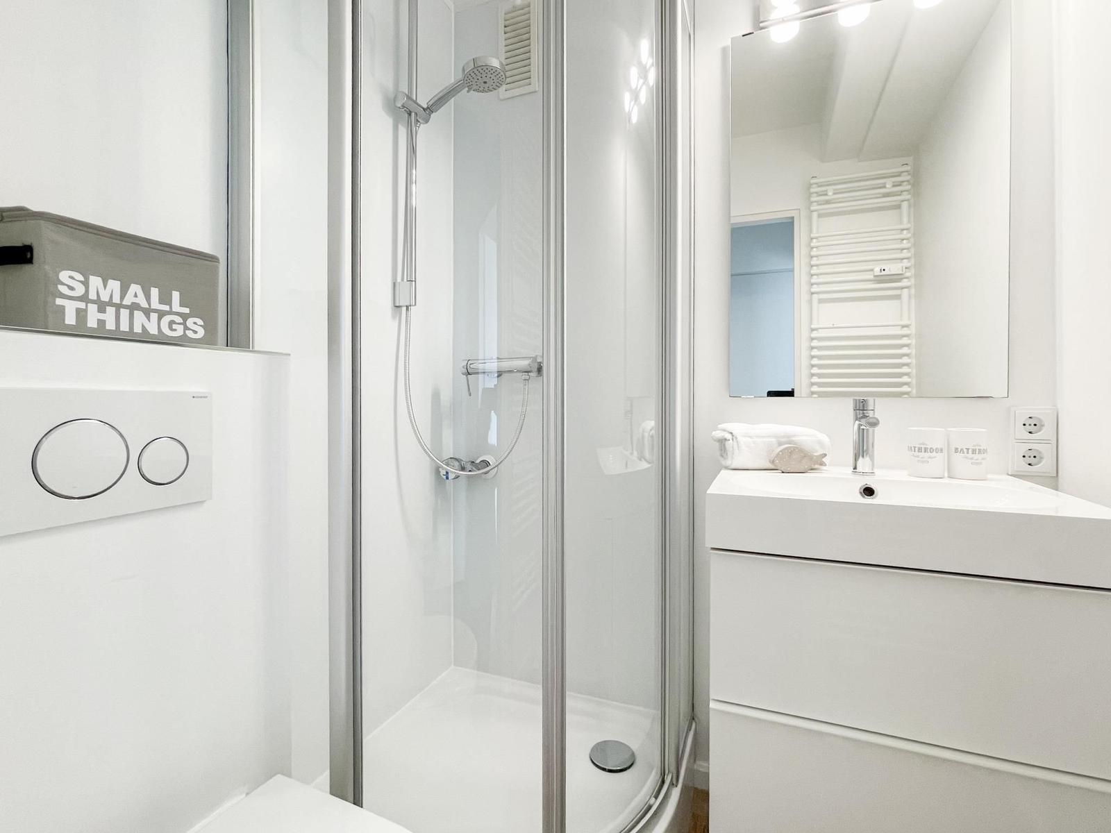 Badezimmer mit Dusche, Waschbecken und Spiegel