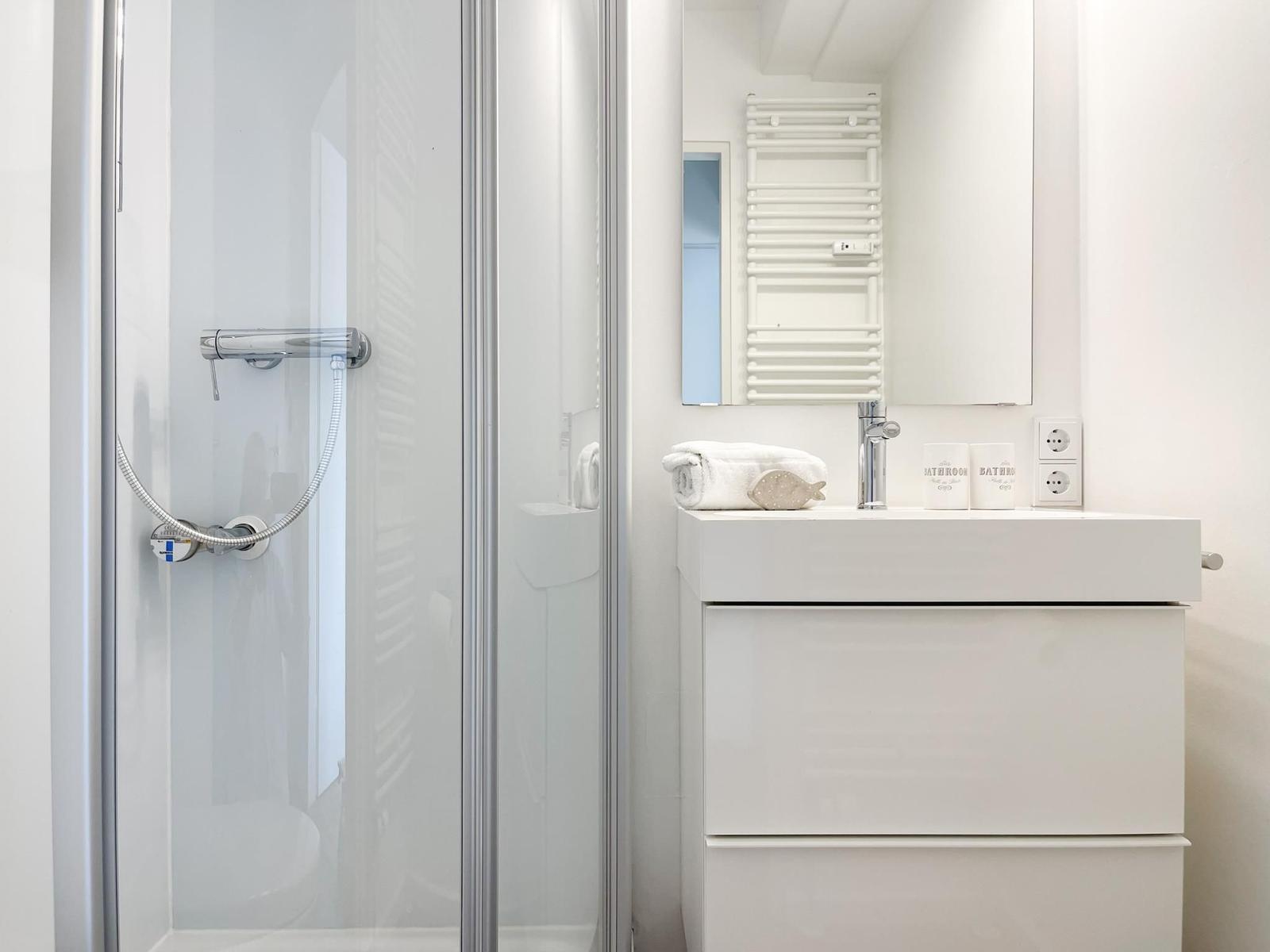 Badezimmer mit Waschbecken, Spiegel und Handtuch.