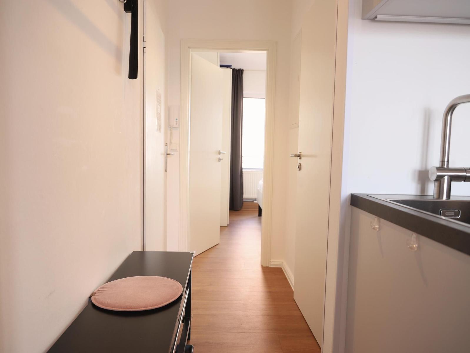 Schlafzimmer mit Doppelbett, Wandbild und Fenster zur Terrasse.