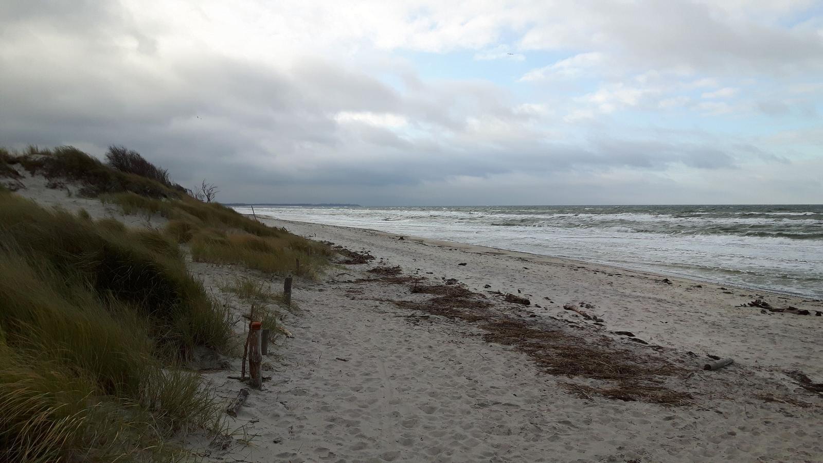 Strand mit Strandkörben, Watt und Himmel mit Wolken.