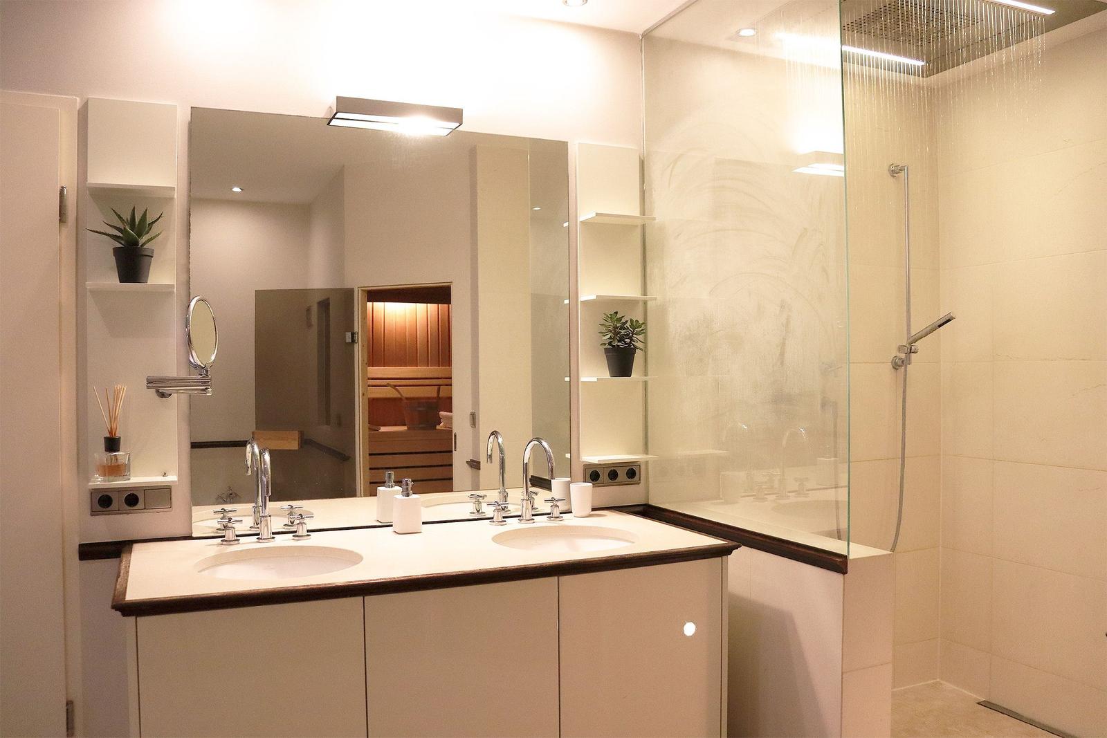 Badezimmer mit Waschbecken, Toilette und Holzregal.