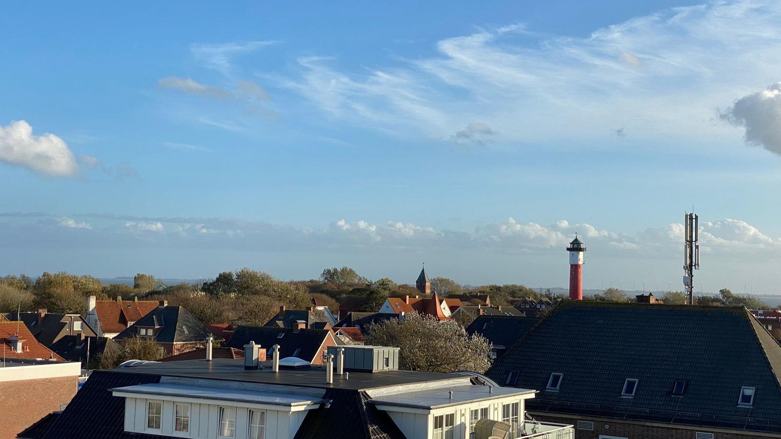 Dachterrasse mit Blick auf Sonnenuntergang und Stadtlandschaft.