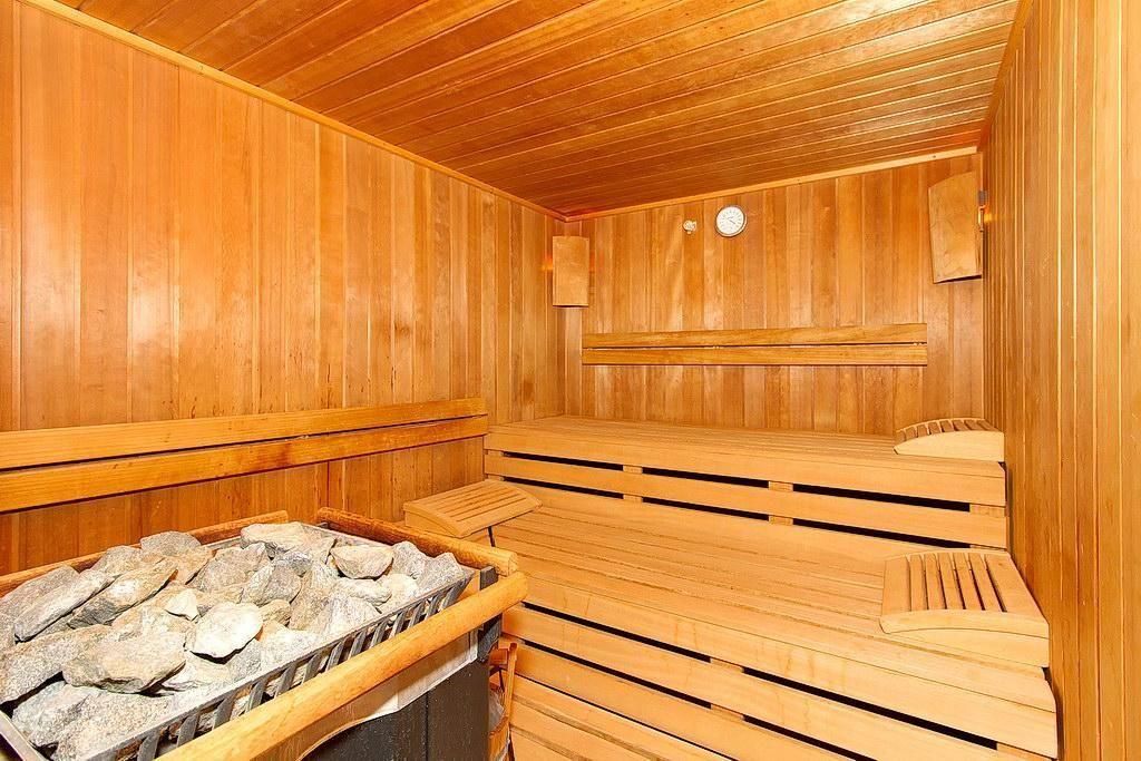 Dusche mit zwei Wasserhähnen und hellen Fliesen. Durchgang zu weiteren Räumen.