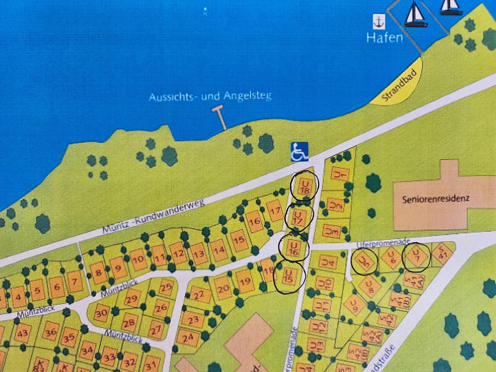 Müritz-Strandhotel mit Restaurant, gepflasterte Allee und Parkplatz.
