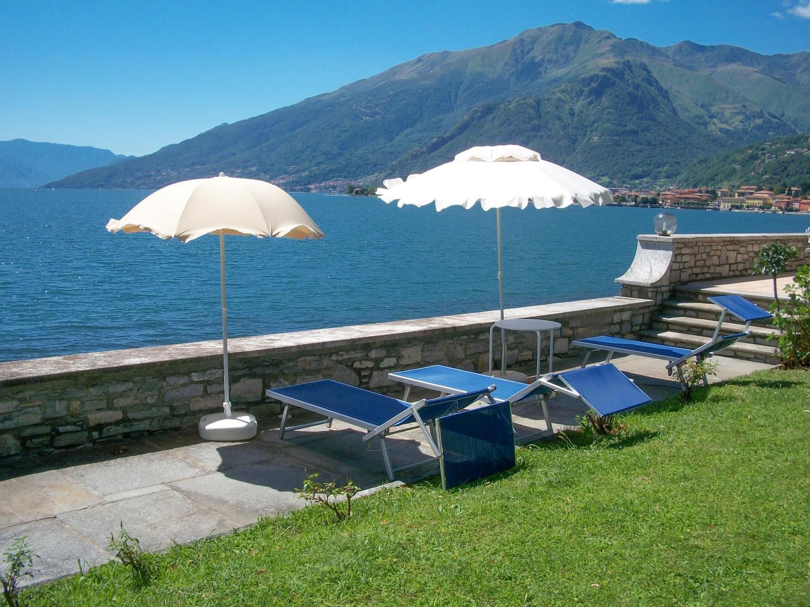 Pool mit Liegestühlen und Blick auf See und Berge