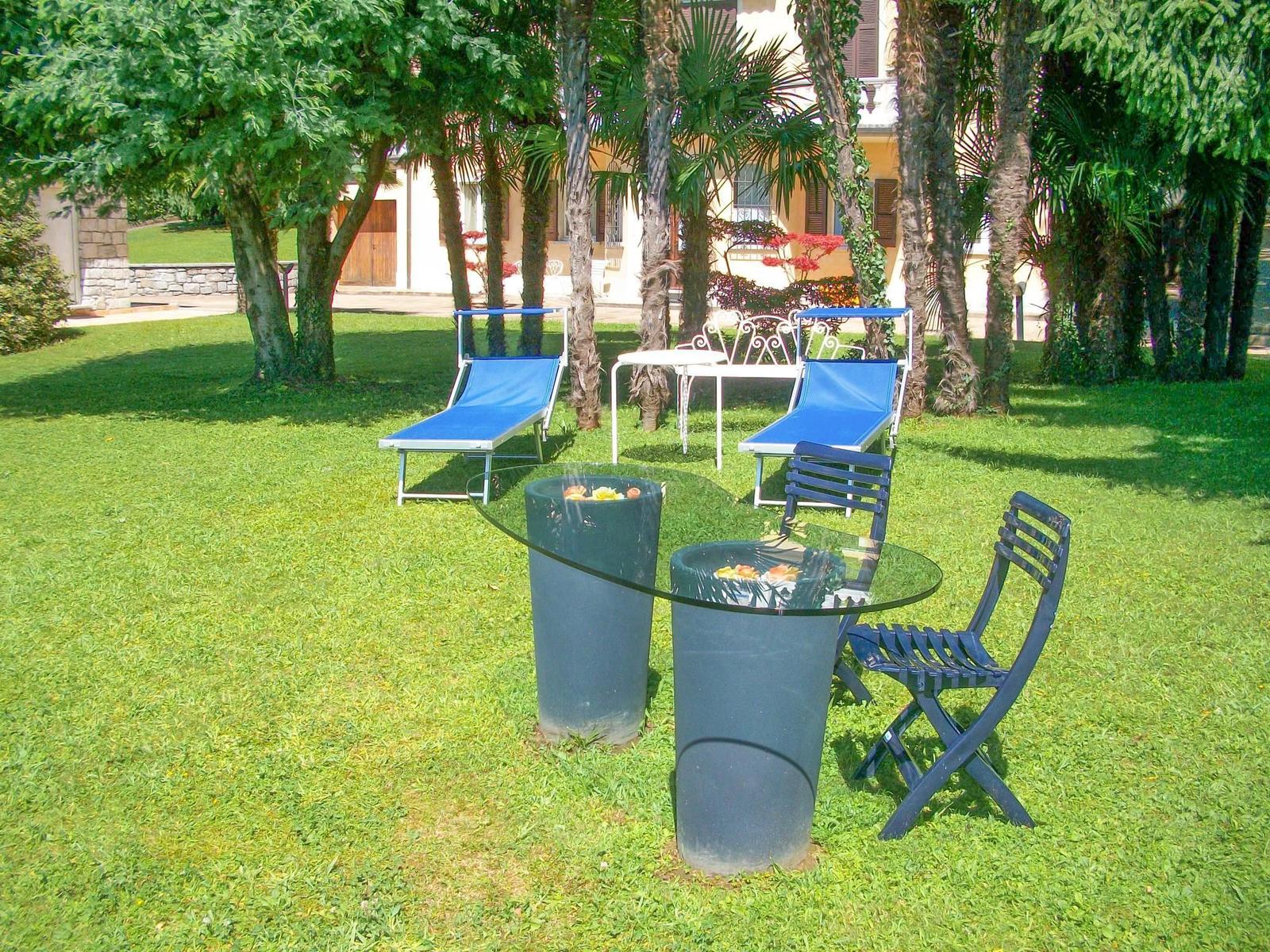 Villa mit Pool, Terrasse und Garten. Umgeben von Bäumen und Bergen.