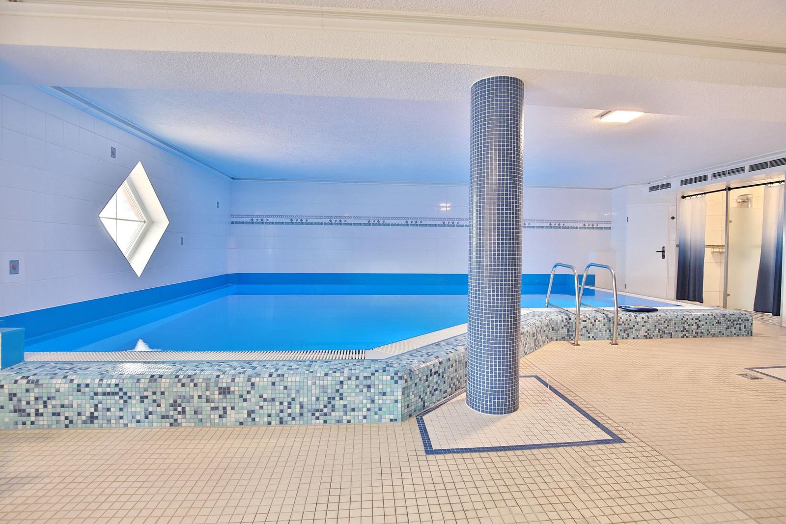 Eine Sauna mit Holzverkleidung, einer weißen Sitzbank und zwei Pflanzen an den Wänden.