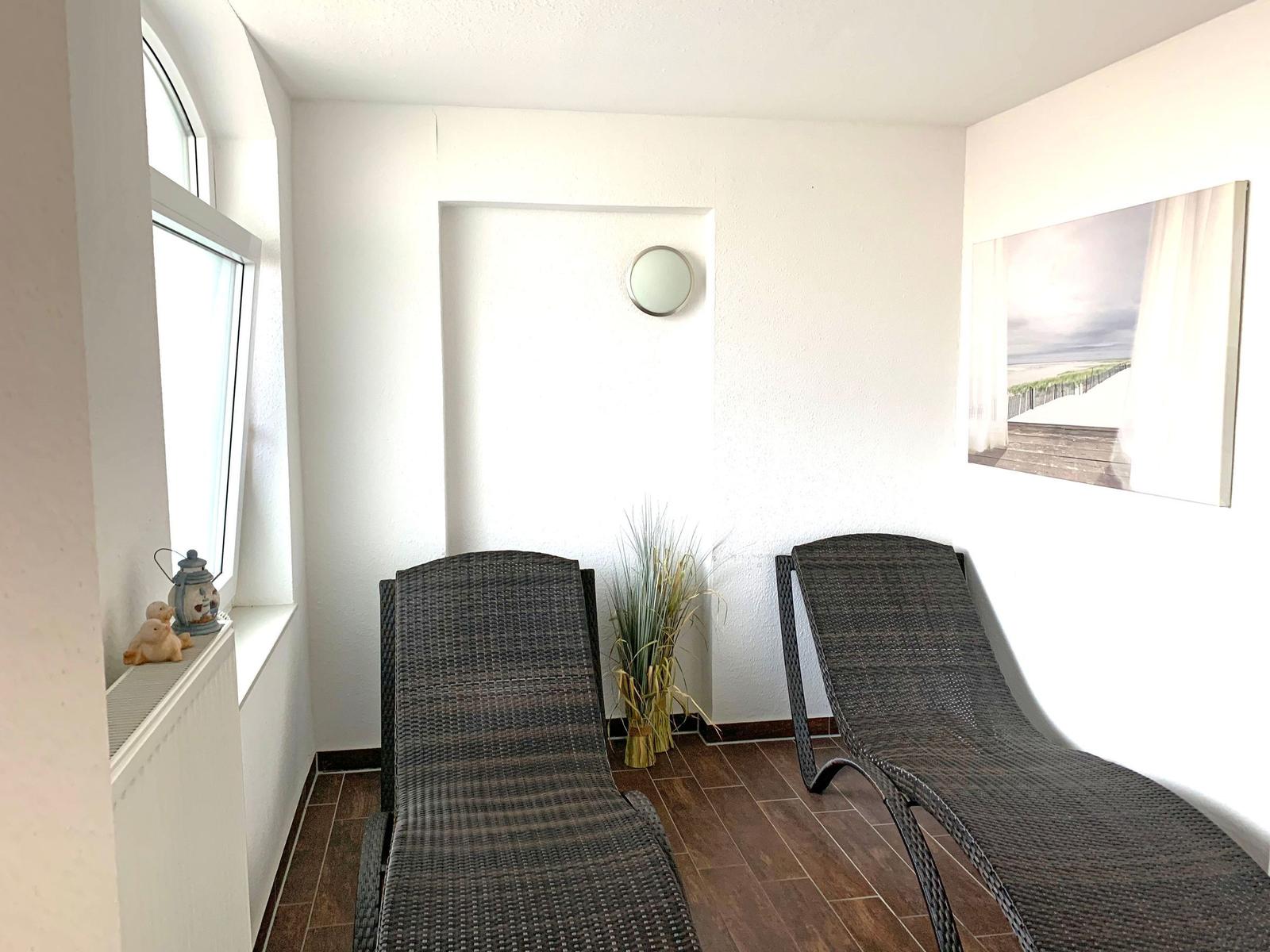 Living and dining area, kitchen, bathroom, bedroom, guest room, and balcony with garden furniture.